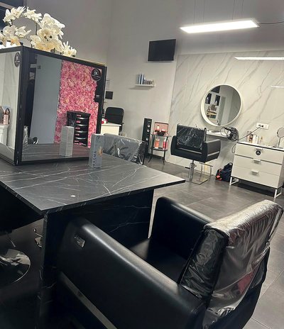 La postazione di lavoro con il piano scuro, lo specchio grande e la parete di fiori riflessa